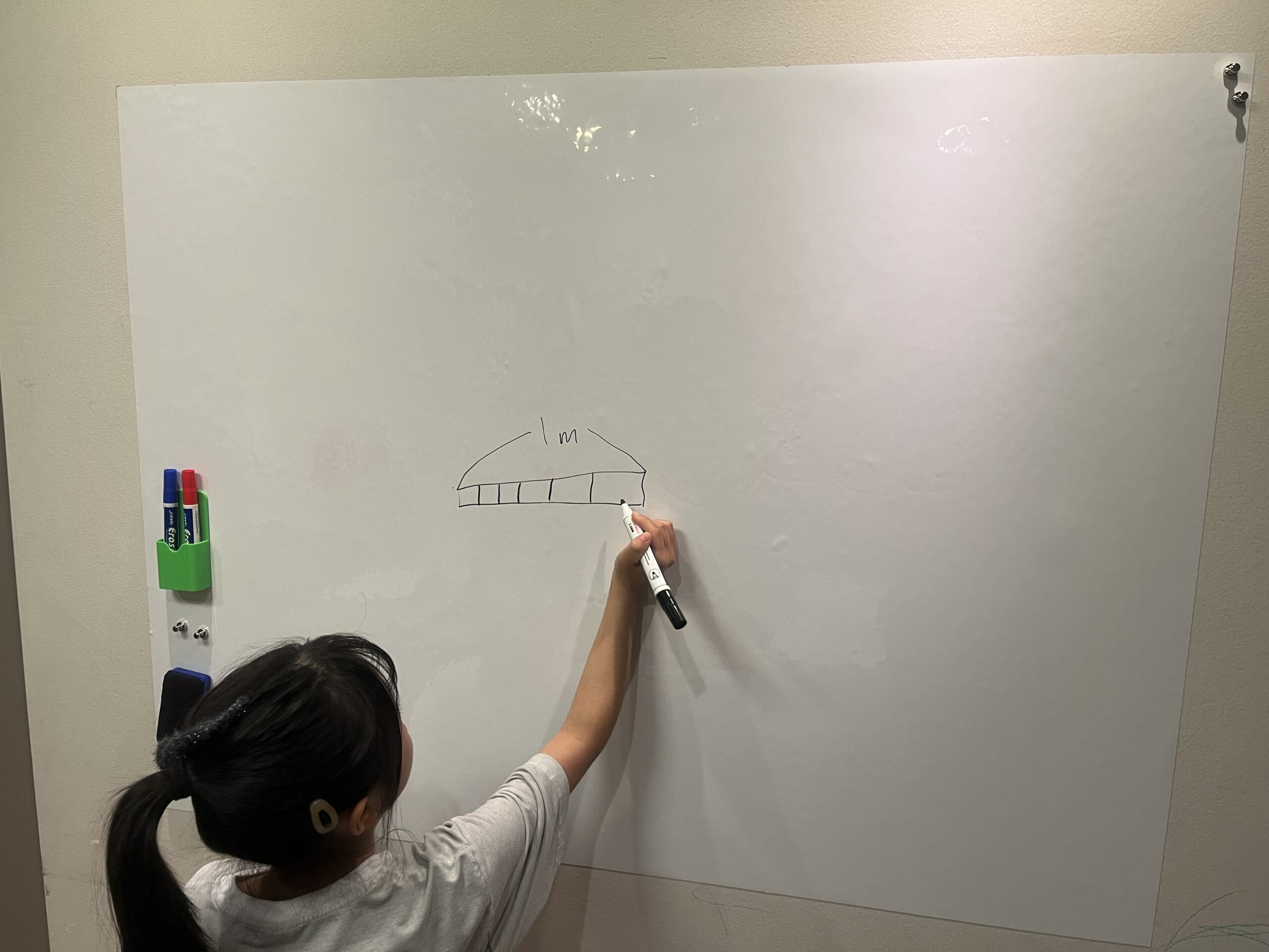 90×120cmのホワイトボードシートに子どもが絵を描いている様子。1mの目安線を書いても、まだ余白がたっぷり残っている